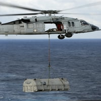 N MH-60S Sea Hawk na putu s pošiljkom zaliha tijekom vertikalnog nadopunjavanja na morskom plakatu tiska
